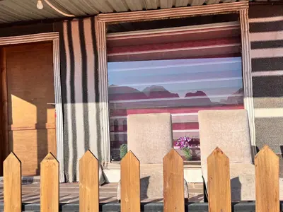 two chairs in front of a window with a fence at Rum luxury star in Wadi Rum