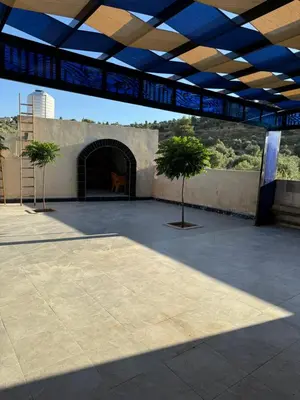 a large patio with two trees in front of a building at البيت الريفي in Jerash