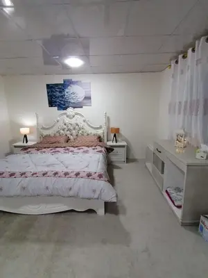 a bedroom with a large white bed and a desk at Al-Karak Countryside and hotel in Ad Dimnah