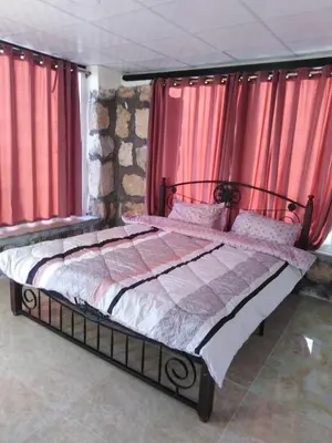 a bed in a room with red curtains at Al-Karak Countryside and hotel in Ad Dimnah