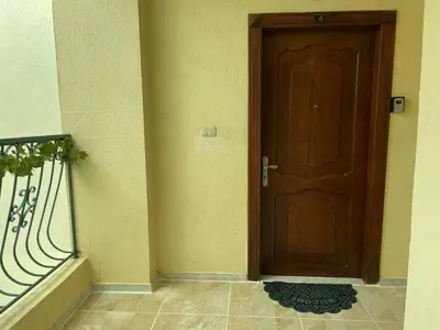 a wooden door in the corner of a building at Khalda Renovated 3 Bedroom Apartment in Amman