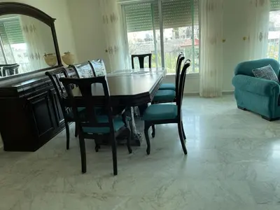 a dining room with a table and chairs at Khalda Renovated 3 Bedroom Apartment in Amman