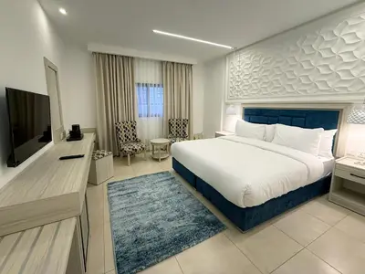 a bedroom with a large bed and a television at Petra Karam Hotel in Wadi Musa