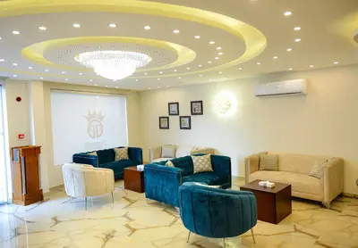 a waiting room with blue chairs and a ceiling at Petra Premium Hotel in Wadi Musa