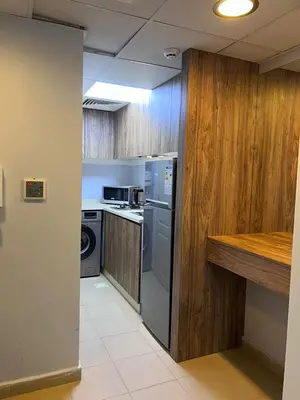 a kitchen with stainless steel appliances and wooden cabinets at new furnished studio gardens st 329 in Amman