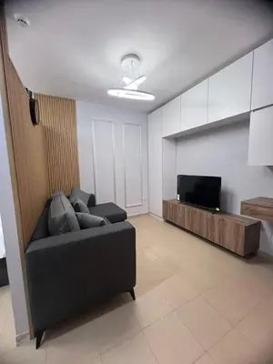 a living room with a couch and a flat screen tv at new furnished studio gardens st 329 in Amman