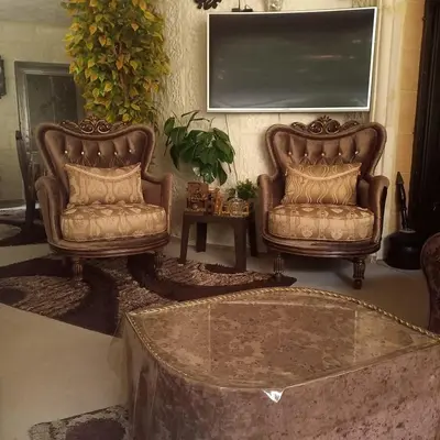 two leather chairs and a table in a living room at شقه مفروشه مع حديقه اربد بجانب فندق فلامنجو ومدارس دار العلوم in Irbid