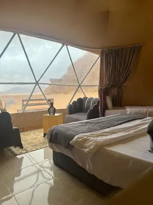 a bedroom with a bed and a view of the desert at Desert Boulevard Camp in Wadi Rum