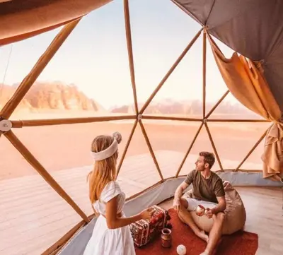 a man and a woman sitting inside a tent at Desert Boulevard Camp in Wadi Rum