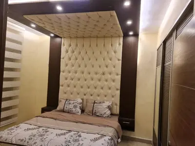 a bedroom with a bed with a padded headboard at 2bd apartment 32 in Amman