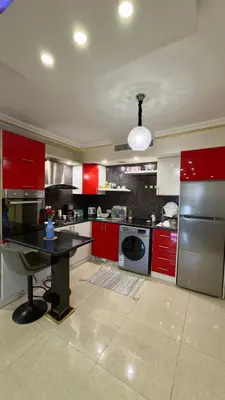 a kitchen with red cabinets and a black counter top at 2bd apartment 32 in Amman