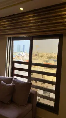 a couch in a room with a large window at 2bd apartment 32 in Amman