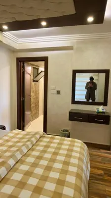 a bedroom with a bed and a tv on the wall at 2bd apartment 32 in Amman