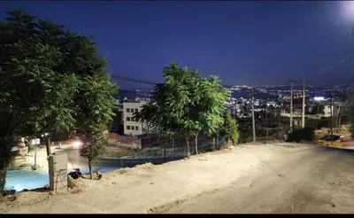 a person sitting on the side of a dirt road at Mickey Mouse studio in Jerash