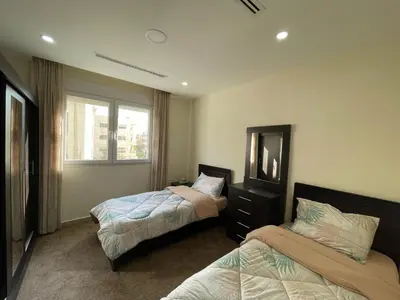 a bedroom with two beds and a mirror at Modern 2-Bedroom Apartment in a Vibrant Neighborhood in Amman