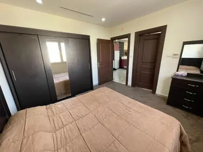 a bedroom with a bed and a dresser and a mirror at Modern 2-Bedroom Apartment in a Vibrant Neighborhood in Amman