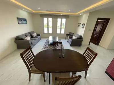 a living room with a table and chairs and a couch at Modern 2-Bedroom Apartment in a Vibrant Neighborhood in Amman