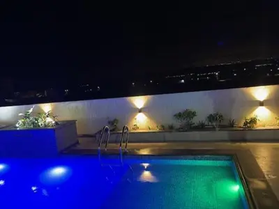 a swimming pool at night with lights on a building at Deadsea Elite second floor shared swimming pool in Sowayma