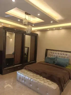 a bedroom with a large bed with a large mirror at اطلالة جرش in Jerash
