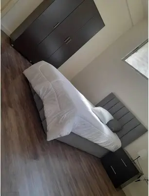 a bedroom with a bed with white sheets and a window at 3bedrooms apt near paris square in Amman