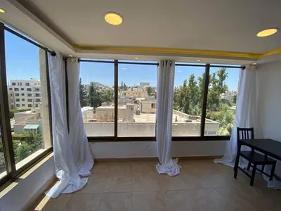 a room with a large window with white curtains at The view III in Amman