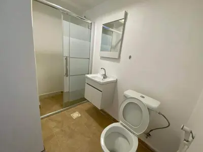 a white bathroom with a toilet and a shower at The view III in Amman