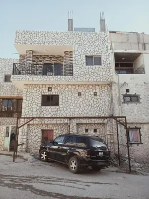 a black car parked in front of a stone building at Margaret from Petra cave house in Wadi Musa