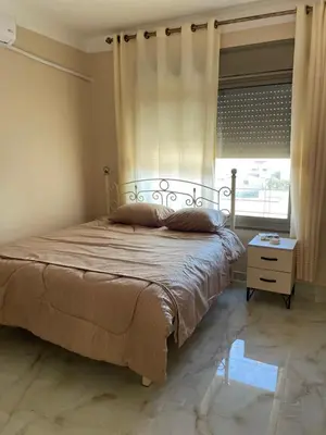 a bedroom with a bed with a window and a table at Airport Villa Amman in Amman