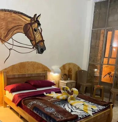 a bedroom with a bed with a horse head on the wall at Dana Star lodge in Dana