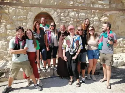 a group of people standing in front of a stone wall at Dana Star lodge in Dana