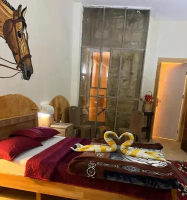 a bedroom with a bed with a horse head on the wall at Dana Star lodge in Dana