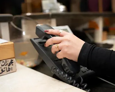 a woman with her hand on a phone at Sama Paris Plaza Hotel in Amman