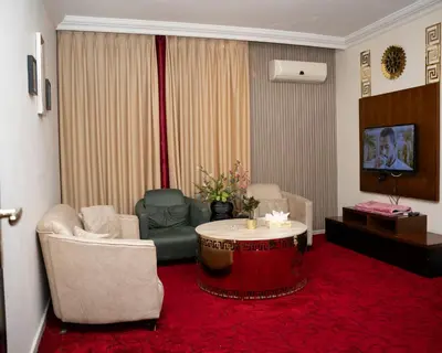a living room with a couch and a table and chairs at Sama Paris Plaza Hotel in Amman
