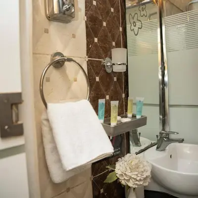 a bathroom with a sink and a white towel at Sama Paris Plaza Hotel in Amman