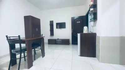 a kitchen with a table and a refrigerator in a room at Salvador Dali Apartments in Amman