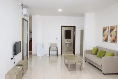 a living room with a couch and a tv at Salvador Dali Apartments in Amman
