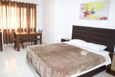 a bedroom with a large bed and a desk at Salvador Dali Apartments in Amman