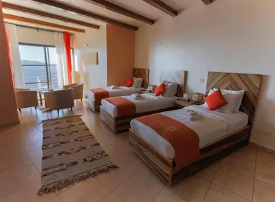 a hotel room with two beds and a balcony at Dana Guesthouse in Dana
