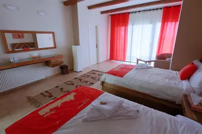 a bedroom with two beds and a window with red curtains at Dana Guesthouse in Dana
