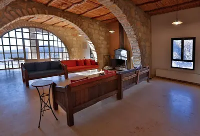 a living room with couches and a table in a building at Dana Guesthouse in Dana