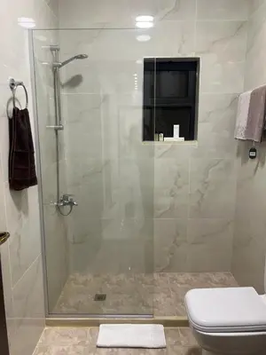 a bathroom with a glass shower with a toilet at Third circle Luxury Hotel apartment in Amman