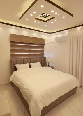 a bedroom with a large white bed in a room at Third circle Luxury Hotel apartment in Amman