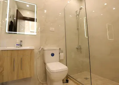 a bathroom with a toilet and a glass shower at Third circle Luxury Hotel apartment in Amman