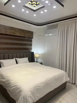 a bedroom with a large white bed in a room at Third circle Luxury Hotel apartment in Amman