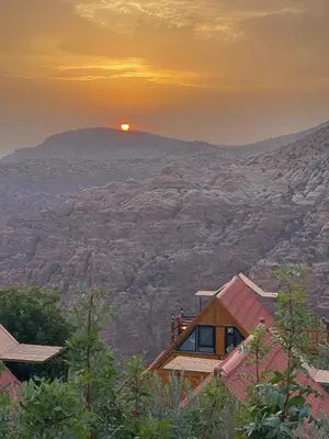 a house on a hill with the sunset in the background at Dana luxury huts in Dana