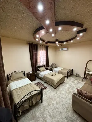 a room with three beds and a couch in it at Bedouin family home in Wadi Musa