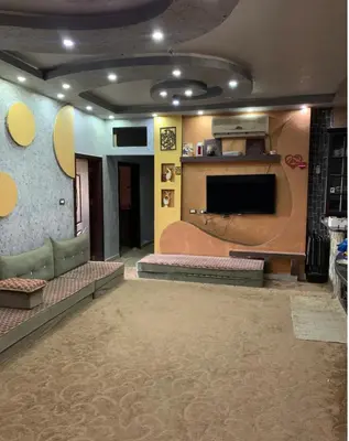 a living room with a couch and a flat screen tv at Bedouin family home in Wadi Musa