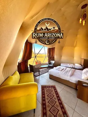 a room with a bed and a sign that reads run africanvana at RUM ARIZONA lUXURY CAMP in Wadi Rum