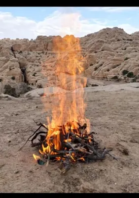 a fire in the middle of a field with rocks at Dana Village Lodge in Dana