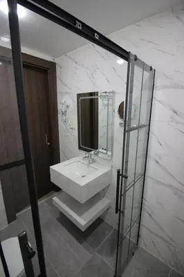 a white bathroom with a sink and a mirror at Beirut Hotel 2 in Amman